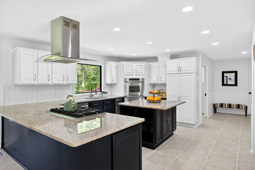 Kitchen island with gas cooktop and stainless vent hood at 106 Riverbank Ct in Moore SC