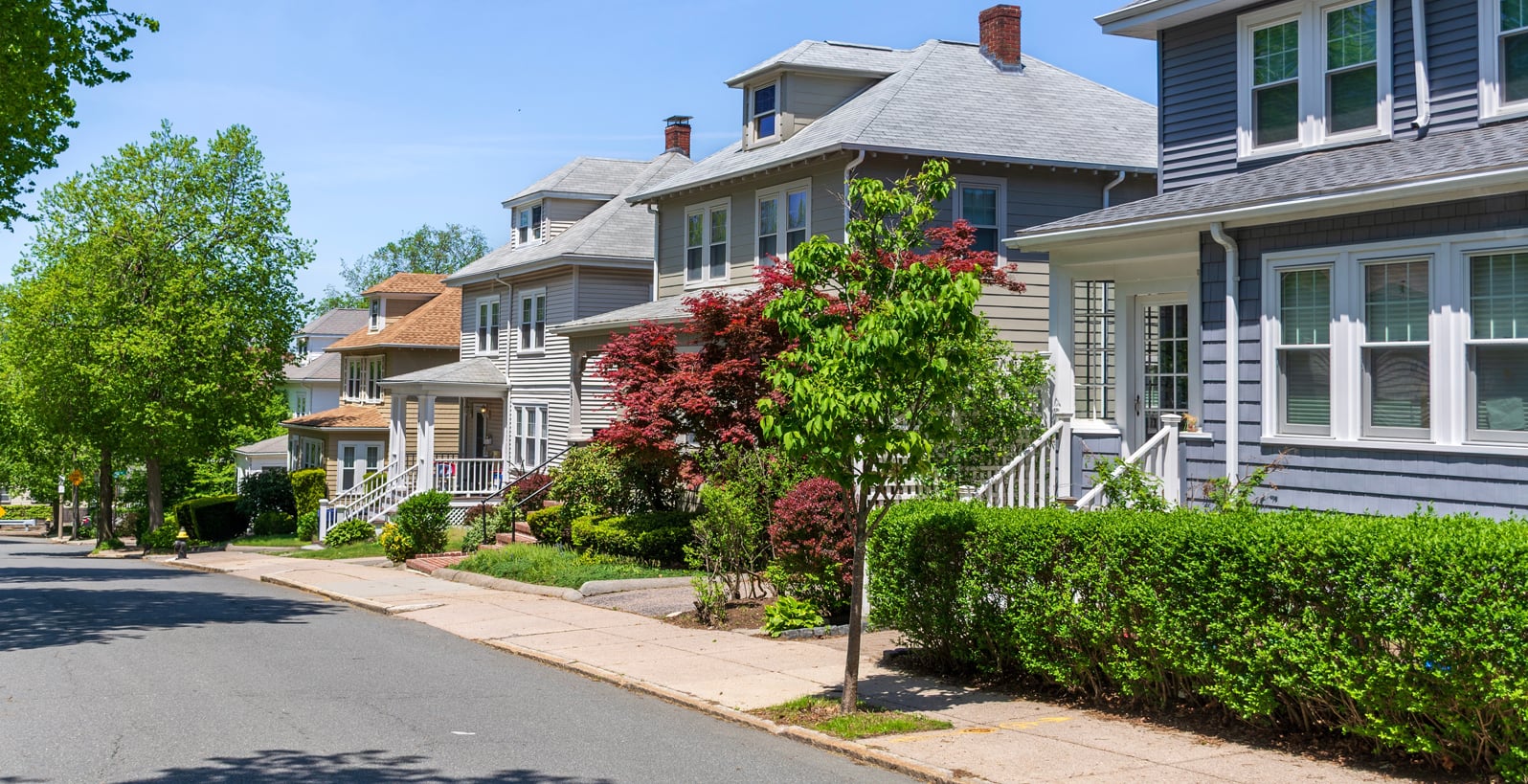 Beautiful-suburban-street-lined-with-traditional-American-homes-on-a-late-spring-day-in-Boston,-Massachusetts,-USA