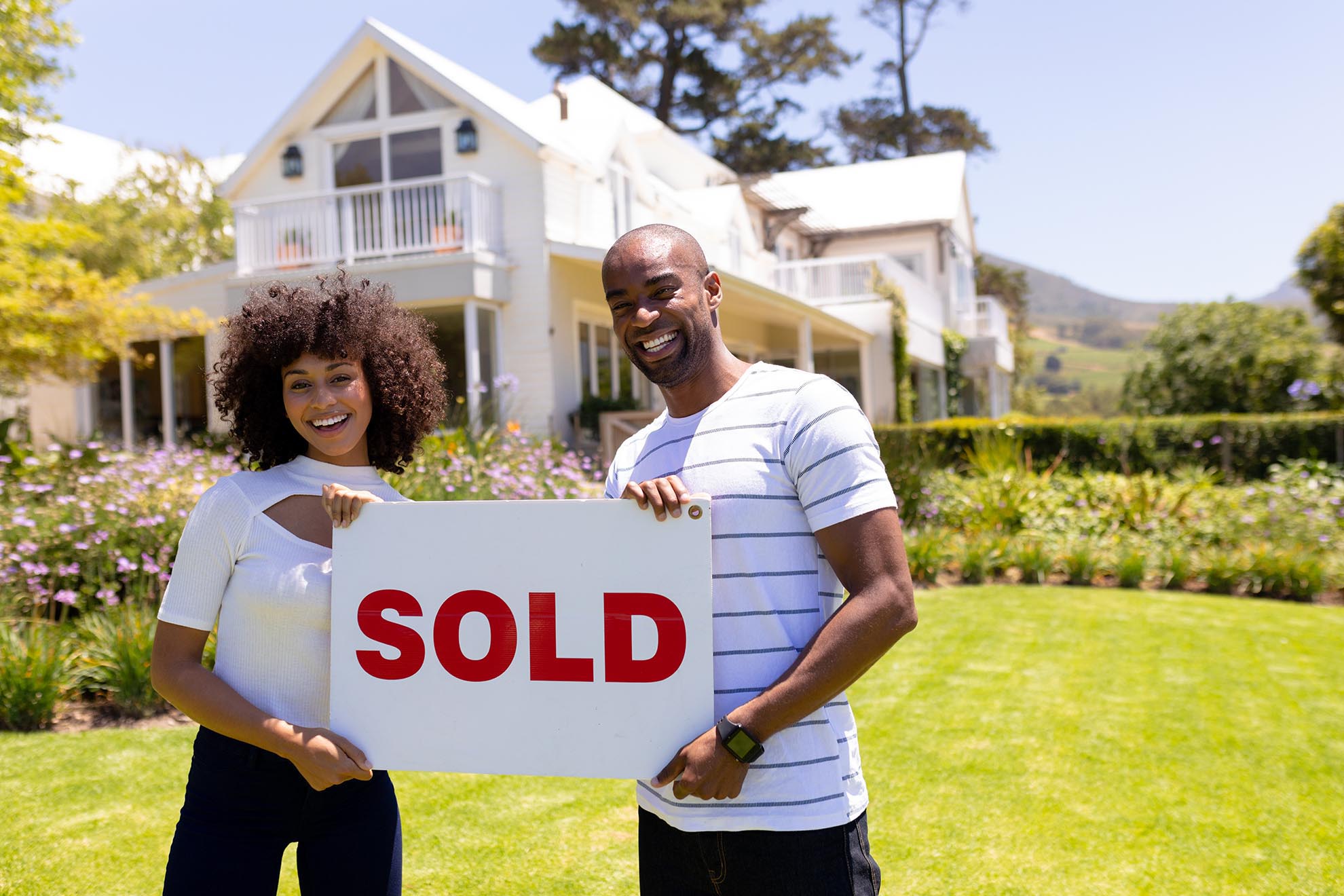 Happy young african american couple in the garden holding sold s