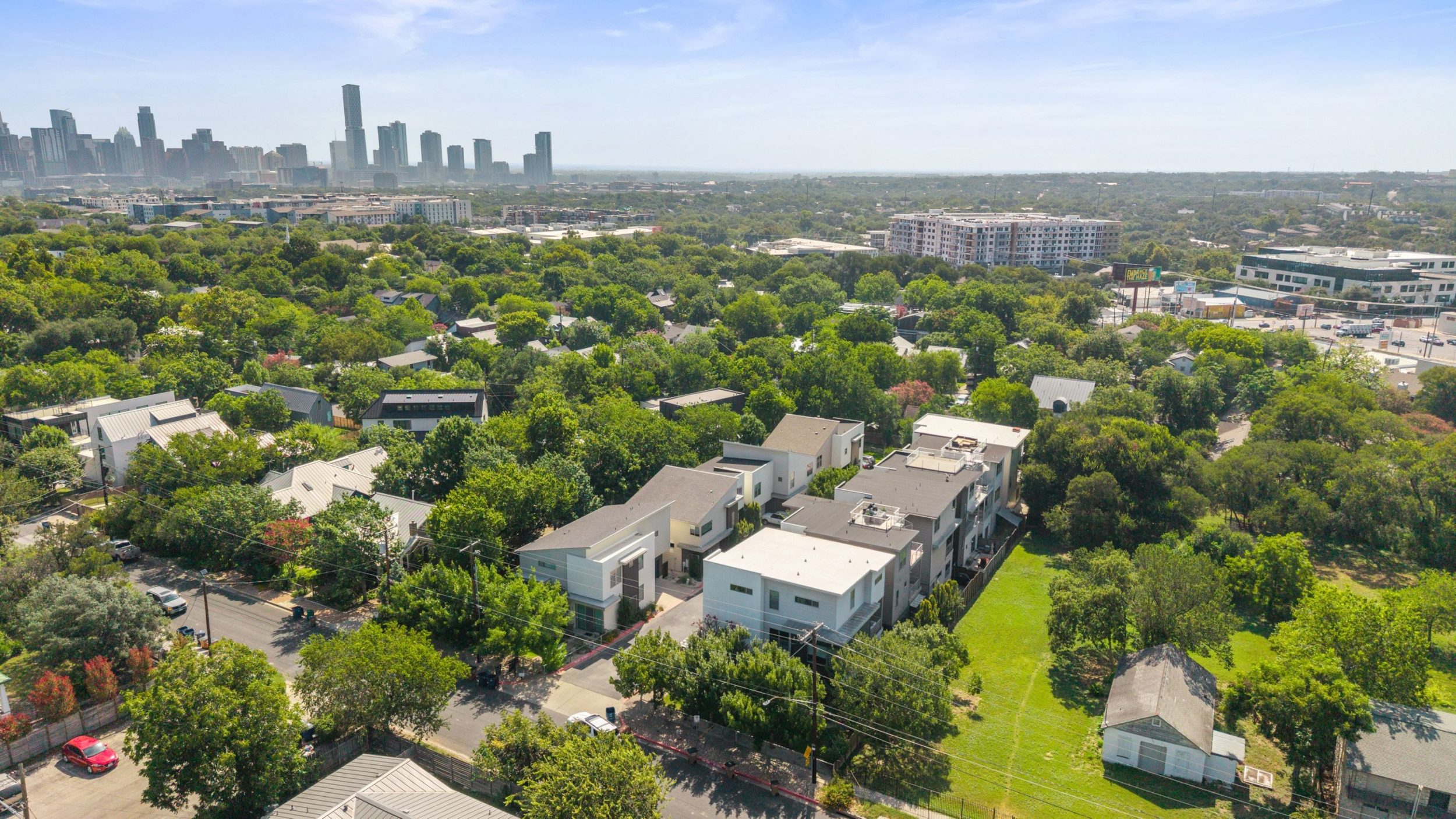 Aerial view of a central Austin neighborhood with the downtown skyline behind it