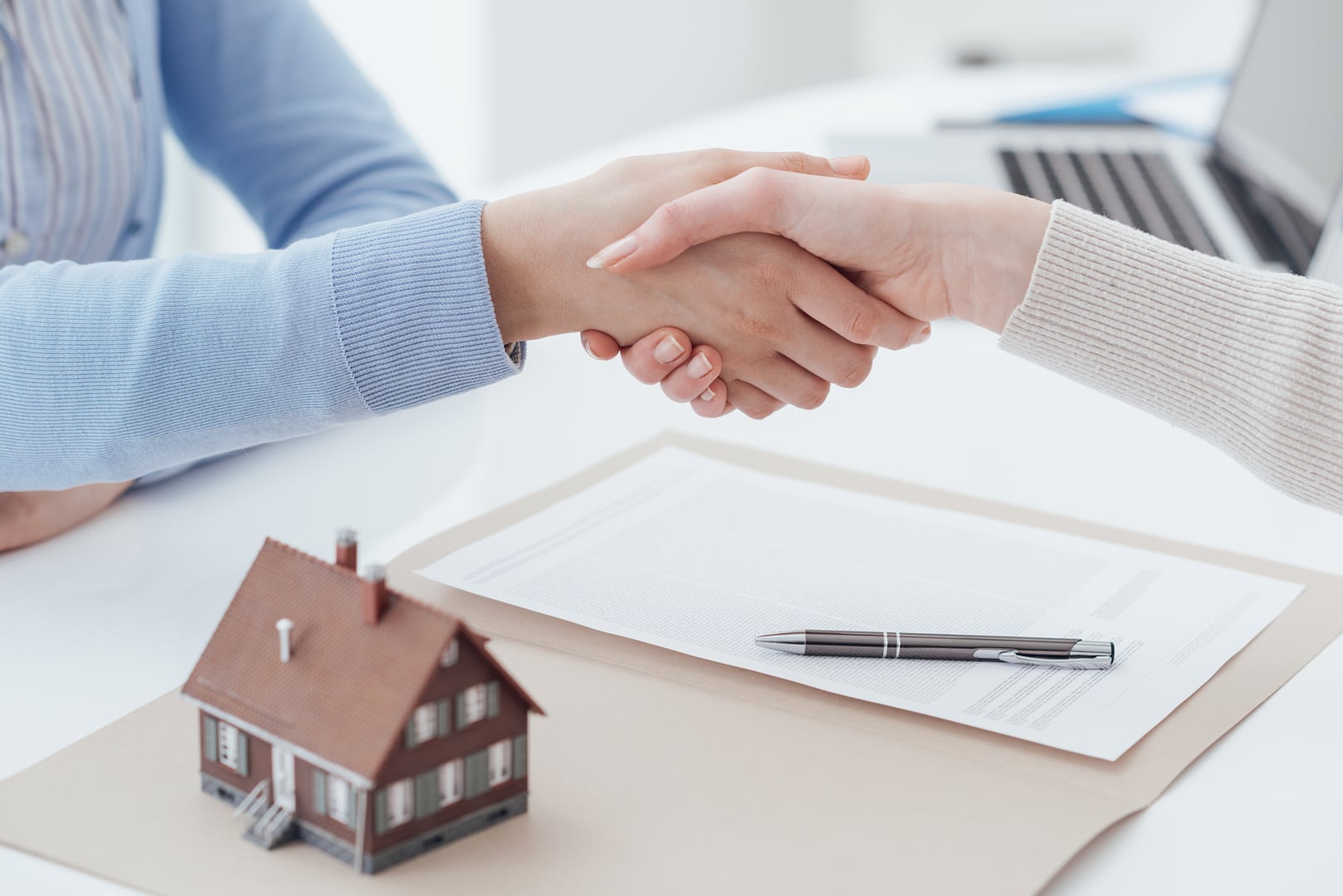 Real-estate-broker-and-customer-shaking-hands-after-signing-a-contract-real-estate,-home-loan-and-insurance-concept