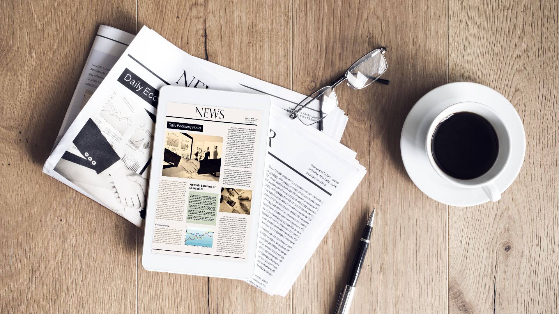 Newspaper with tablet on wooden table (1) (1)