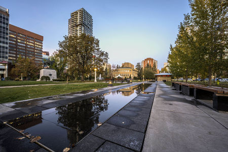 A low angle shot of the beautiful buildings and skyscrapers captured under the blue sky in Calgary, Canada