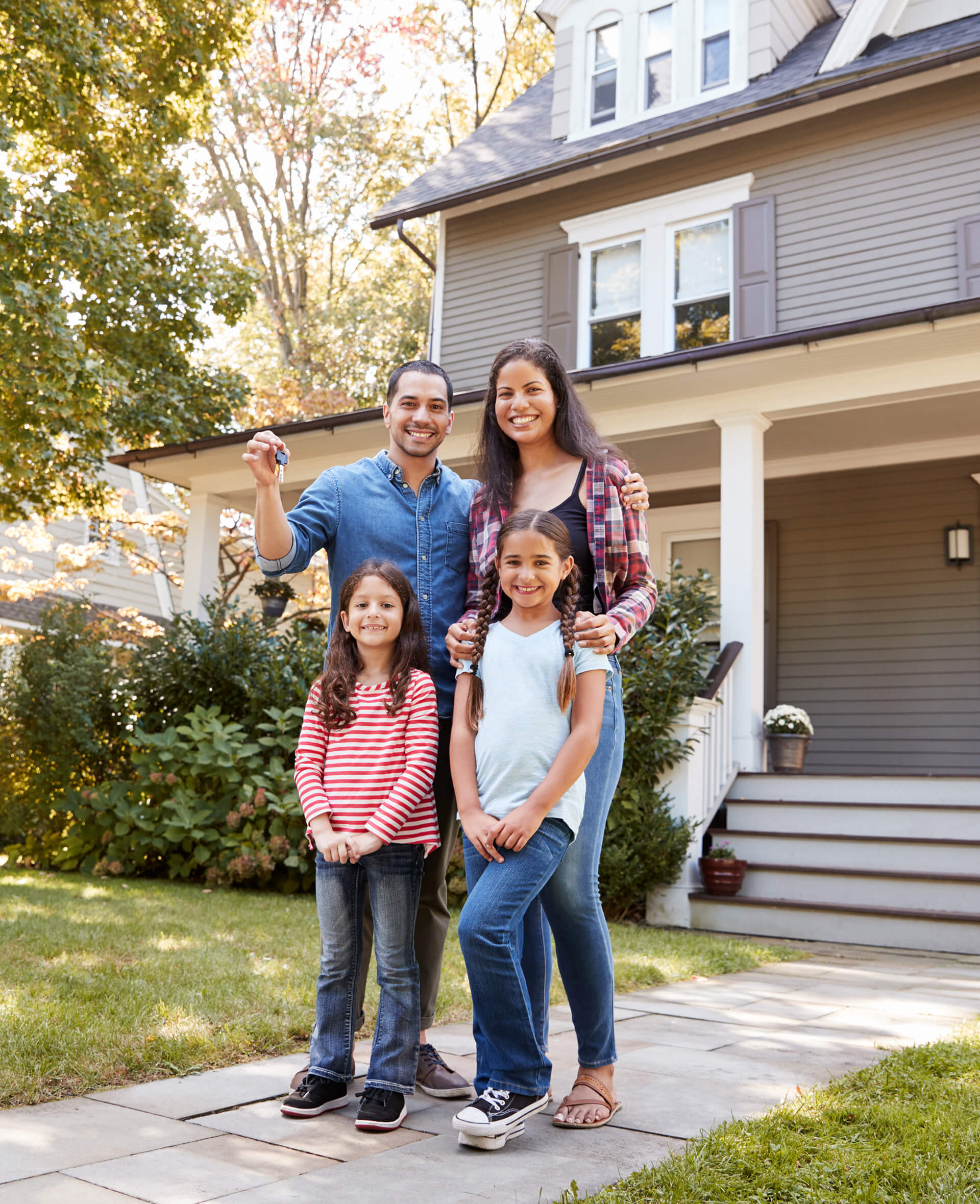 Portrait Of Family Holding Keys To New Home On Moving In Day