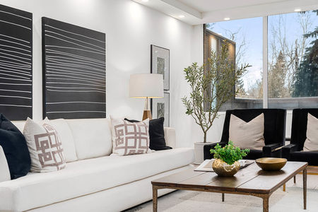 s105, 330 26 Ave SW, Cnada interior home. Livingroom whit white delicate sofa, small table and black pillows