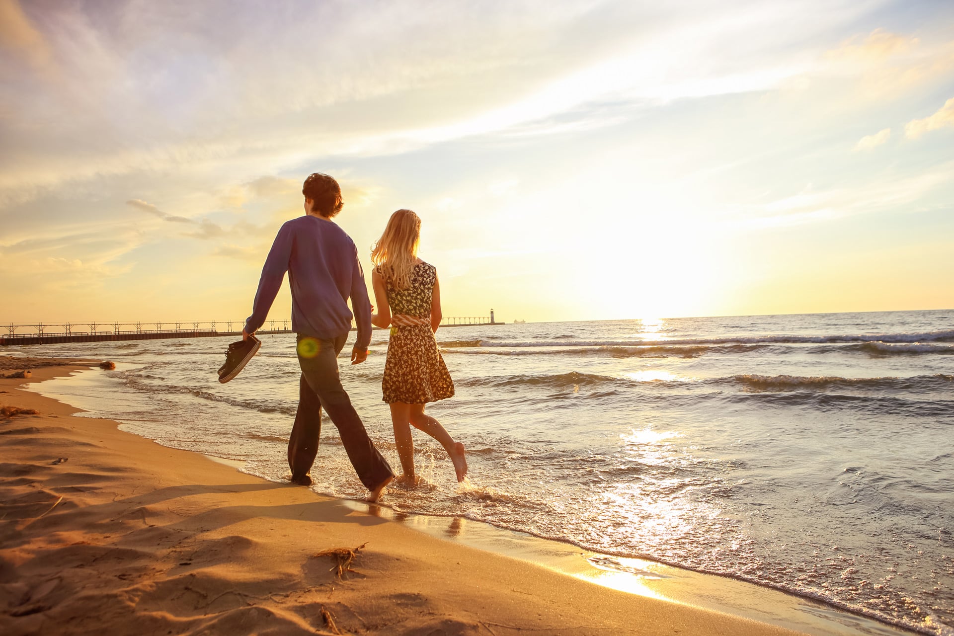 Couple-walking-on-the-beach-at-sunset