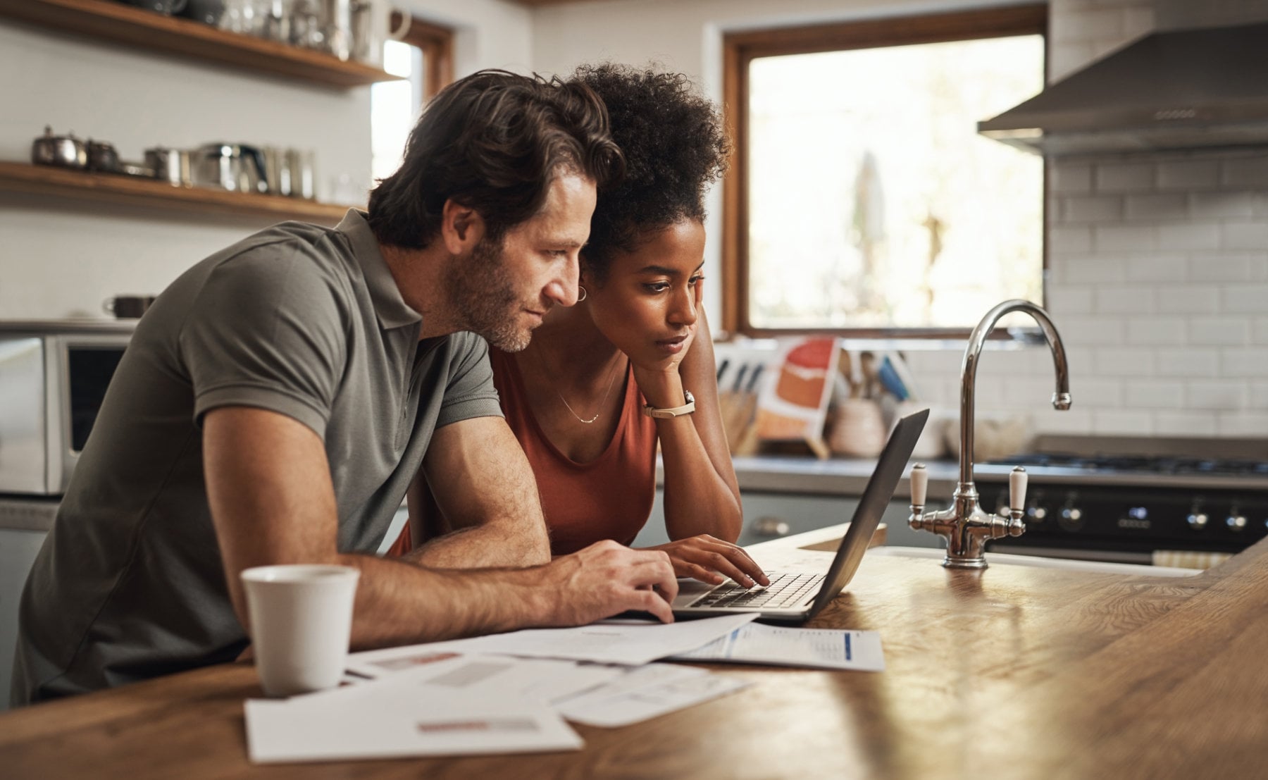 Laptop,,Couple,And,Financial,Planning,In,A,Kitchen,With,Documents