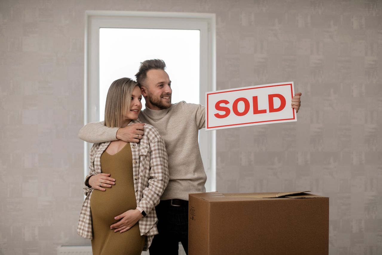 couple-holding-for-sale-sign