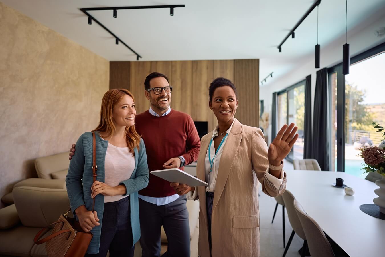 real estate agent using digital tablet while showing new house to a couple