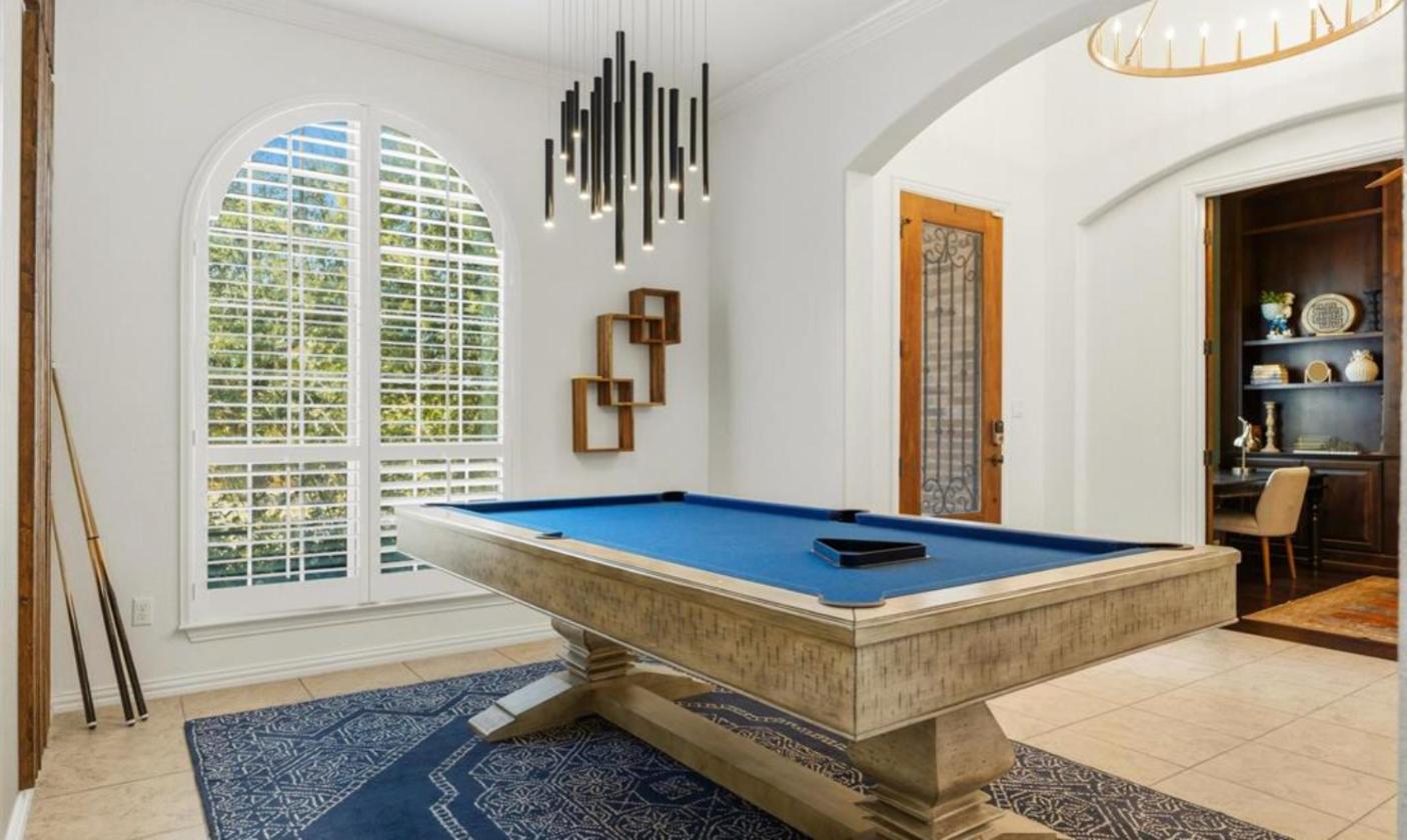 Billiards room with arched window included in the furnished lease at 17312 Wildrye Dr, Rocky Creek Ranch