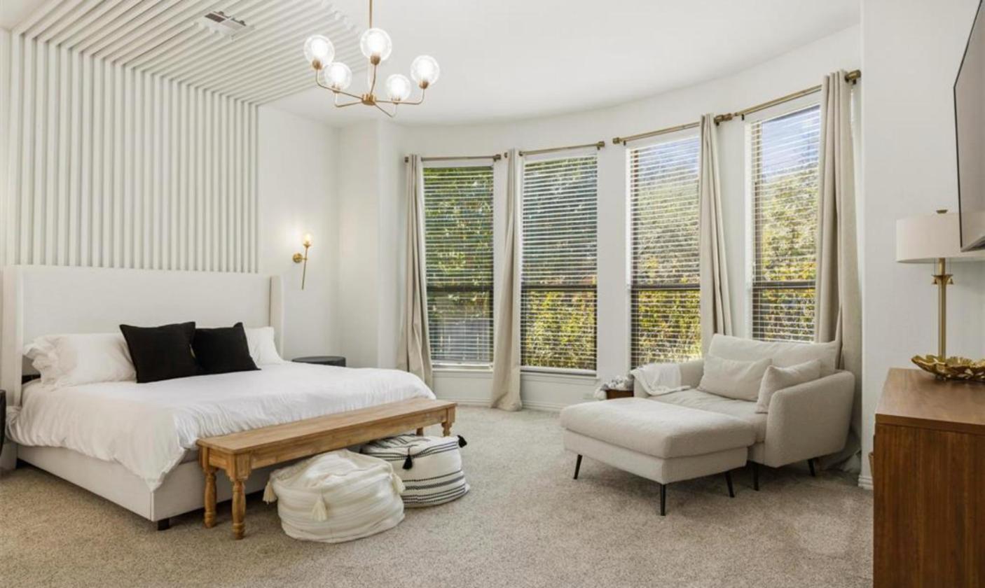 Main-floor primary bedroom with bay windows at 17312 Wildrye Dr, Rocky Creek Ranch Austin