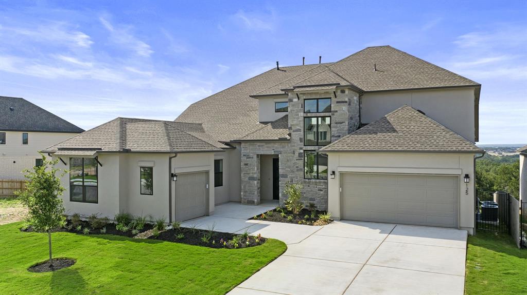 Two-story Toll Brothers home with a stone entry and three-car garage in Santa Rita Ranch, Liberty Hill, Texas