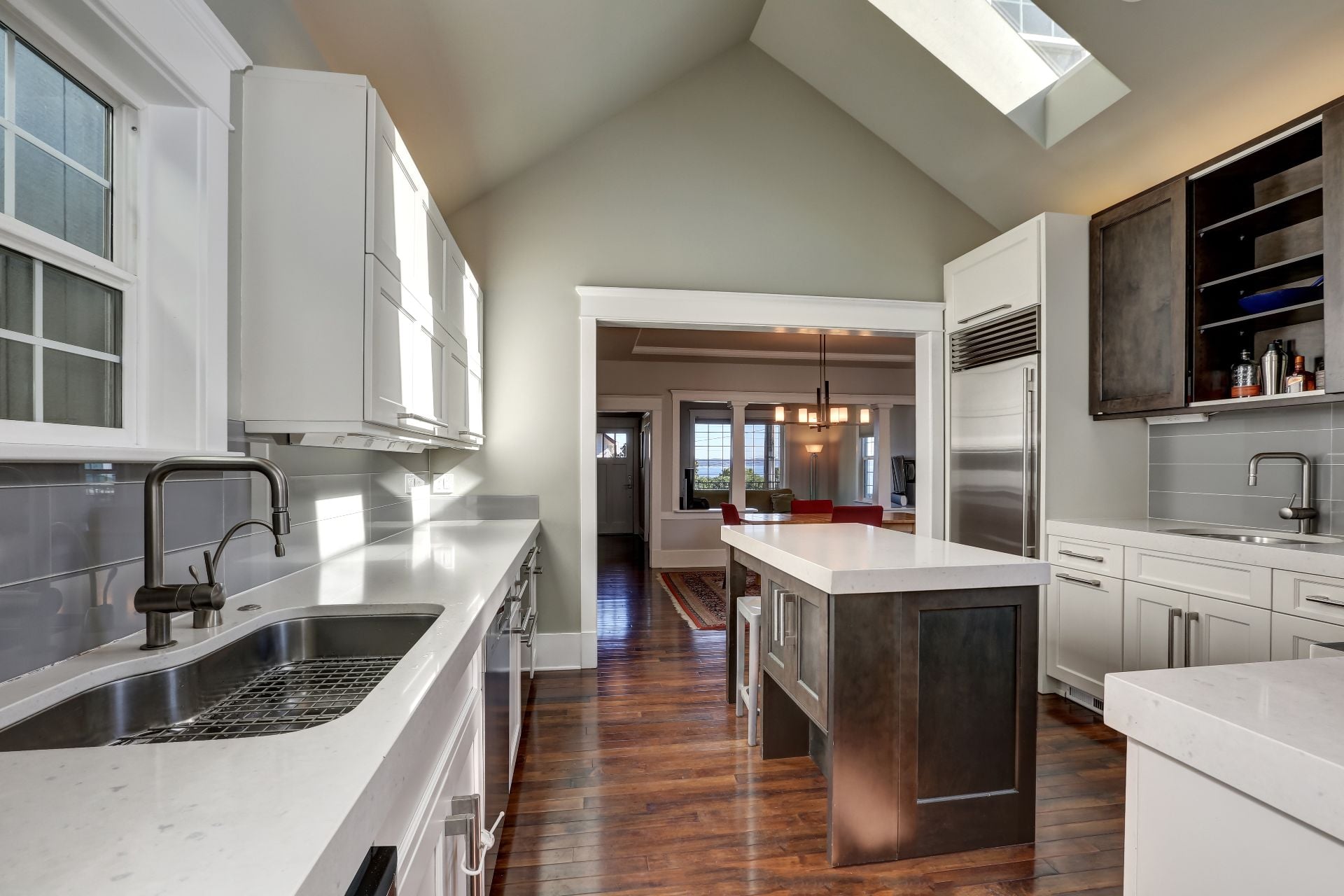 Modern style kitchen interior with brown and white cabinets, stainless steel appliances and vaulted ceiling with skylight. Northwest, USA (1)