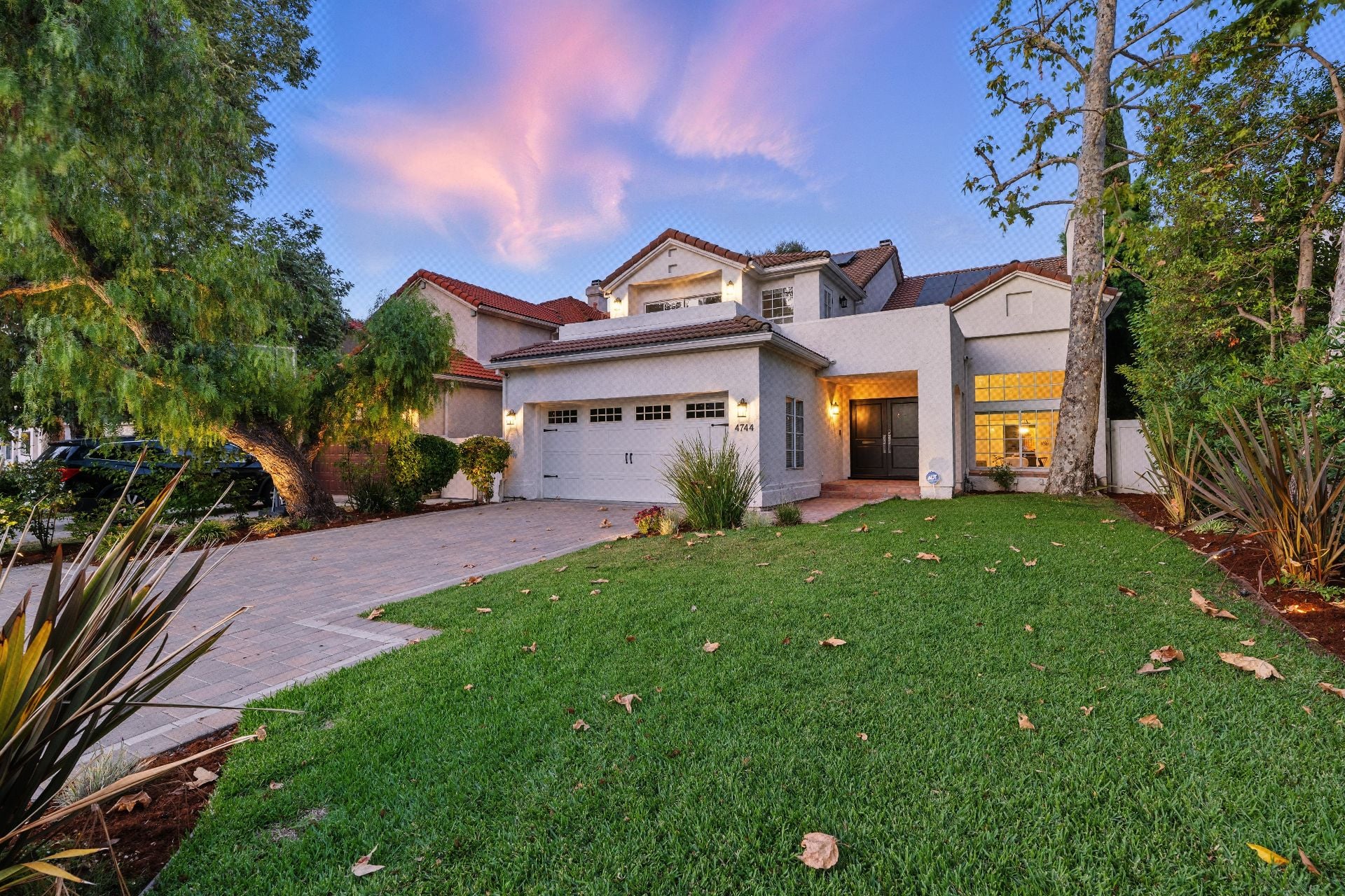 Enchanting two-story traditional with gated curb appeal, a private pool, spa, turf lawn, and cozy string-lit outdoor entertaining area. 3