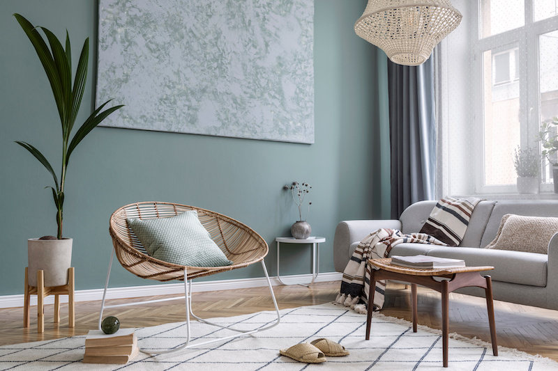 Boho interior design of living room with sofa and rattan armchair