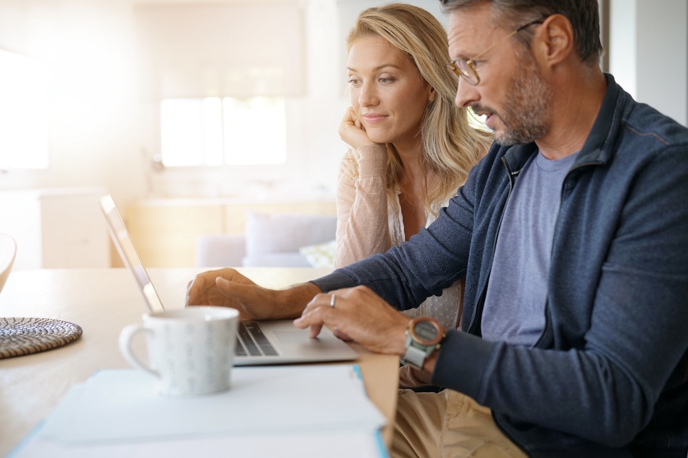 Mature couple at home working on laptop computer