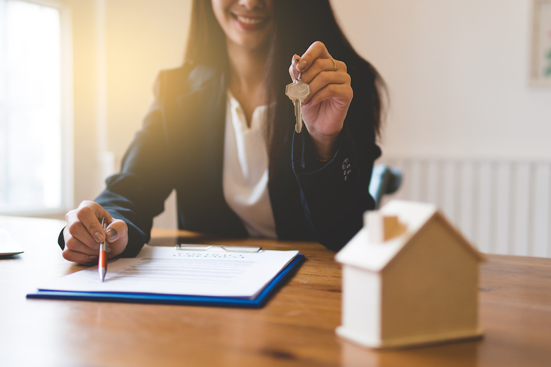 Realtor is giving the keys to an apartment to clients. Focus on the keys.