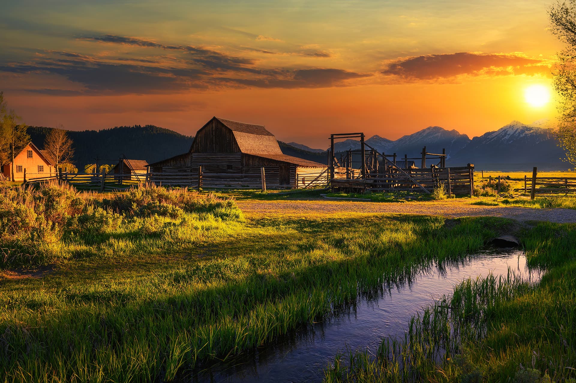 Colorful sunset over Historic John Moulton Barn at Mormon Row in Grand Teton National Park on a sunny summer day, with Teton Mountain Range in the background (1)