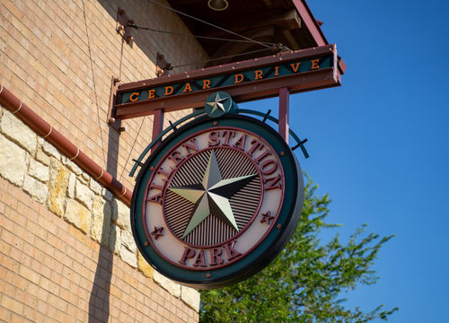 Cedar Drive Allen Station Park Sign With Star Logo On Brick Buil