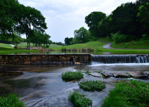 Gold course cart path crossing a small stream late in the evenin