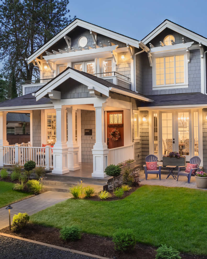 A home at dusk with warm lights glowing in the windows