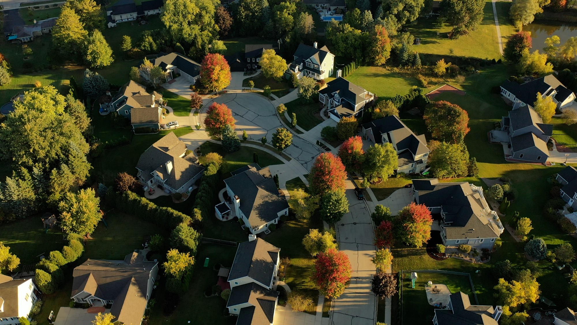 Establishing shot of Midwestern United States. American neighborhood in Fall season. Aerial view of houses. Small town