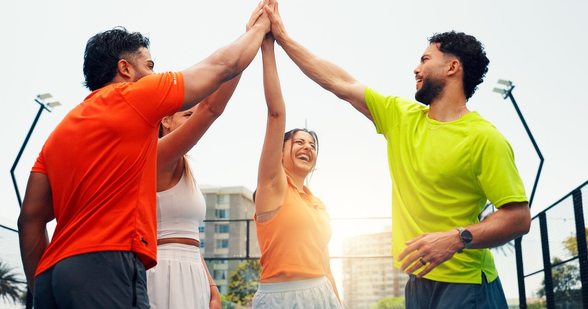 High five, fitness and group of people on court with solidarity, unity and partnership at padel match. Happy, flare and team of athletes with hands together for training, workout or game outdoor.