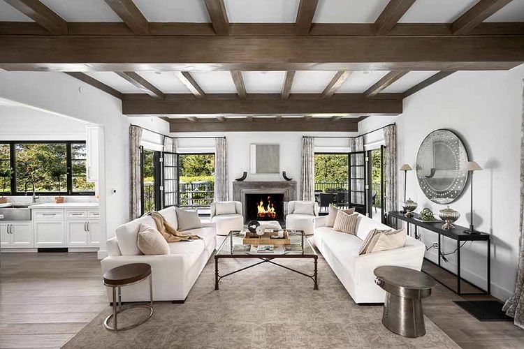 Jones-Pappas-Open-concept-living-area-with-two-white-sofas-and-a-cozy-fireplace
