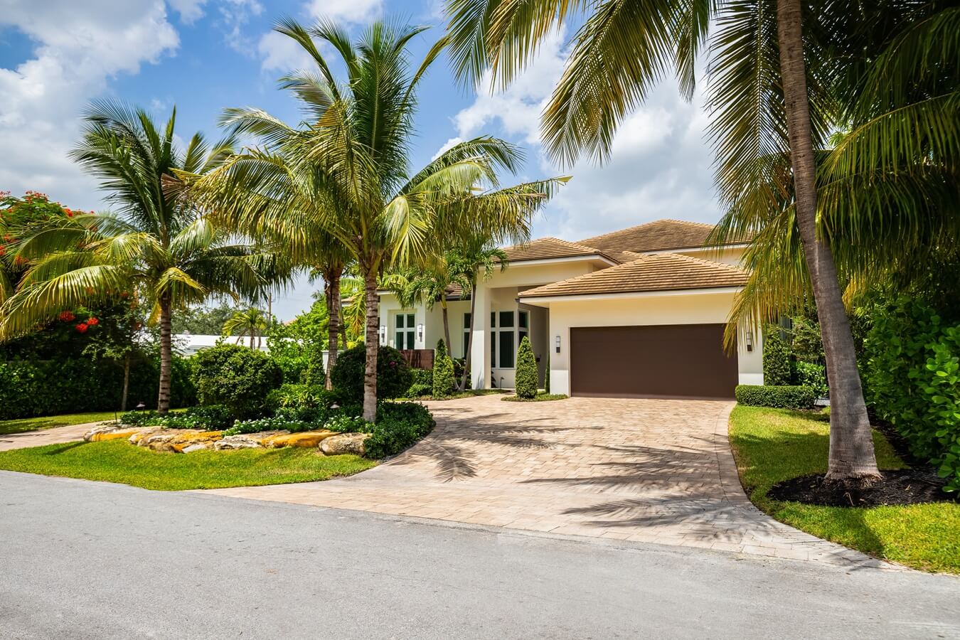 Facade of a beautiful house, with a front garden made up of palms