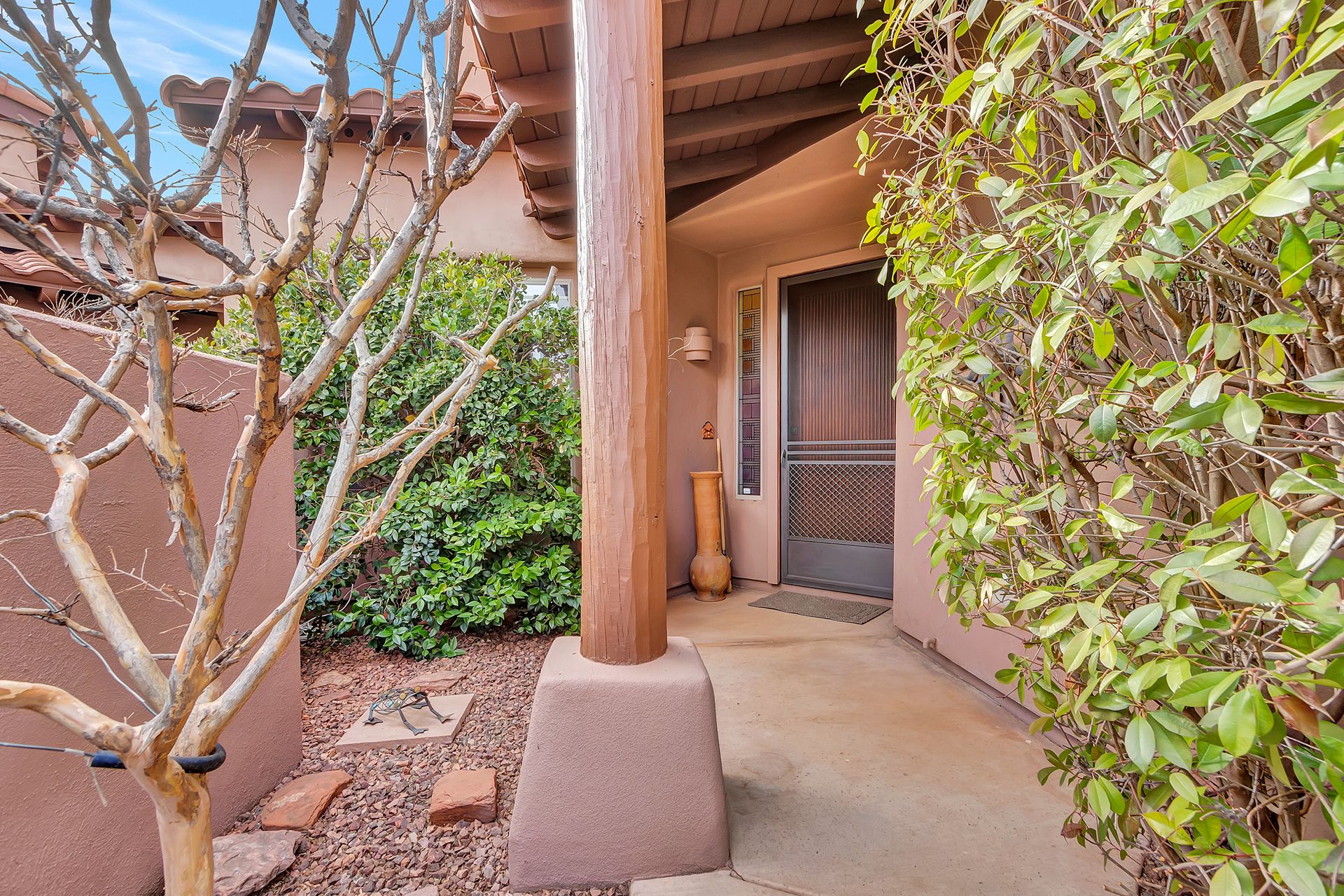 Sedona home courtyard entrance featuring Southwestern architecture, native landscaping, and covered walkway
