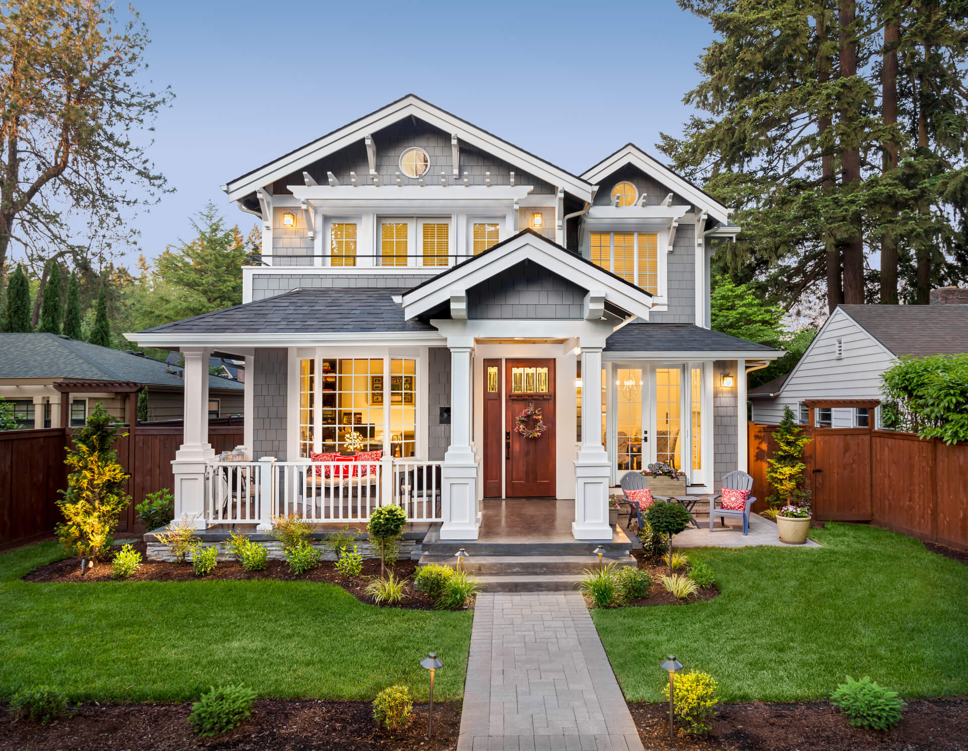 Beautiful Luxury Home Exterior in Evening with Glowing Interior Lights.