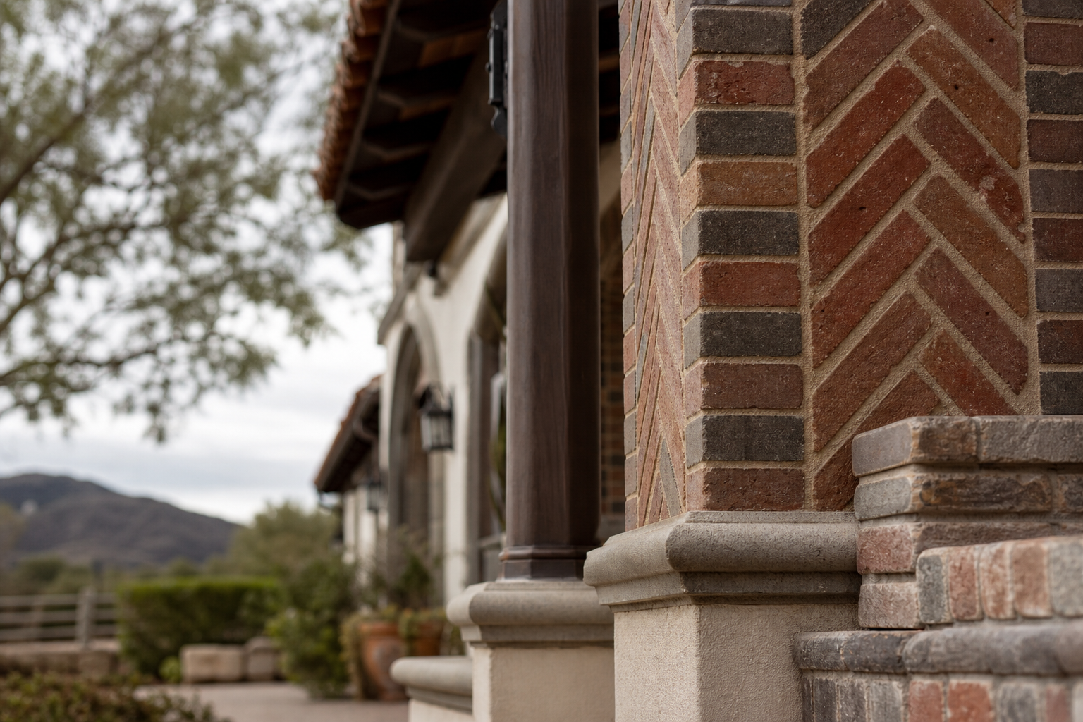 Brick and stone entry columns on a Temecula-area home with open hillside and ranch land in the background