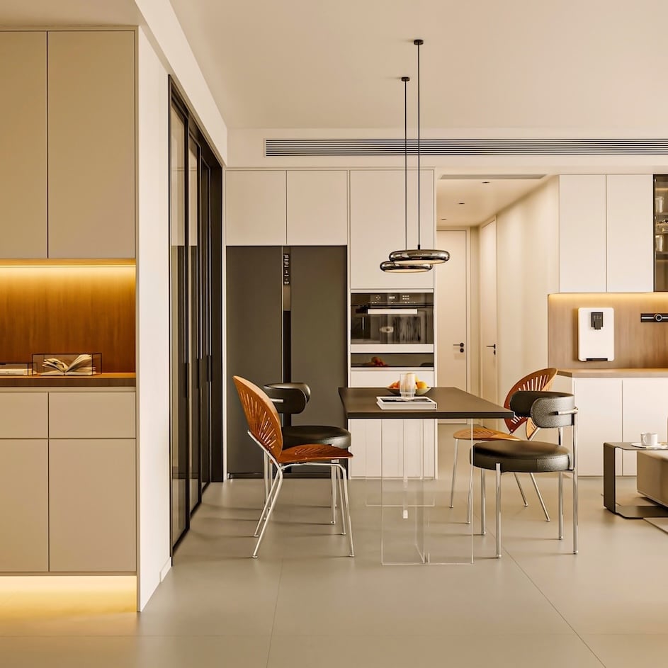 A bright, modern open-plan space featuring a light-toned kitchen with integrated appliances, a sleek dining area, and a cozy living room
