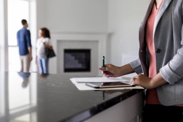 Real Estate Agent Finishing Up Paperwork Home Buyer iStock-1179026137