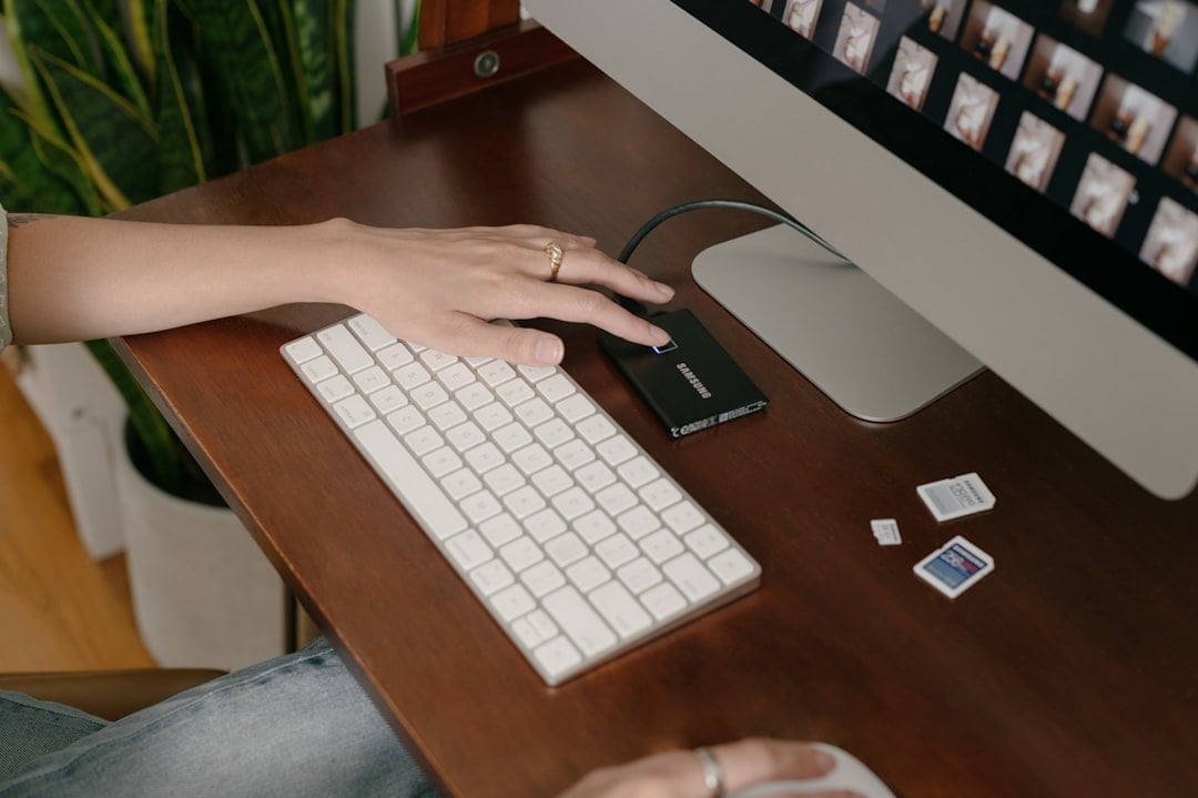 Person sits at a modern desk, using a calculator next to a set of house keys, representing a landlord analyzing their prop...