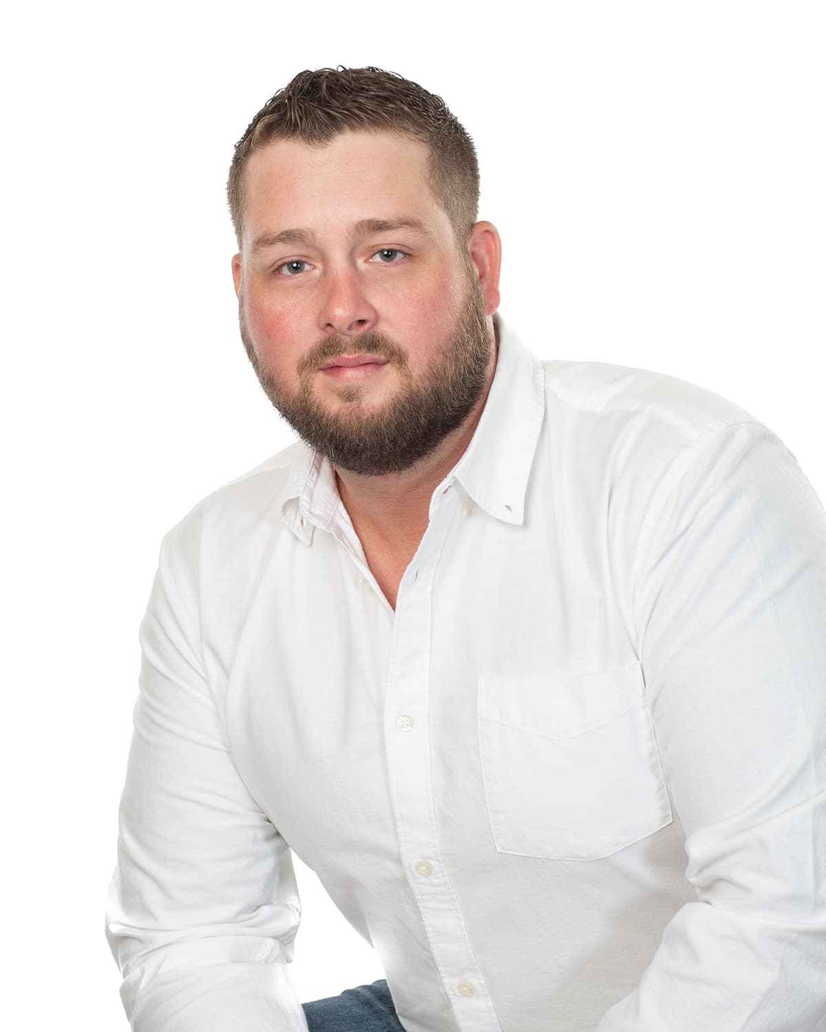 A man with a beard wearing a white collared shirt.