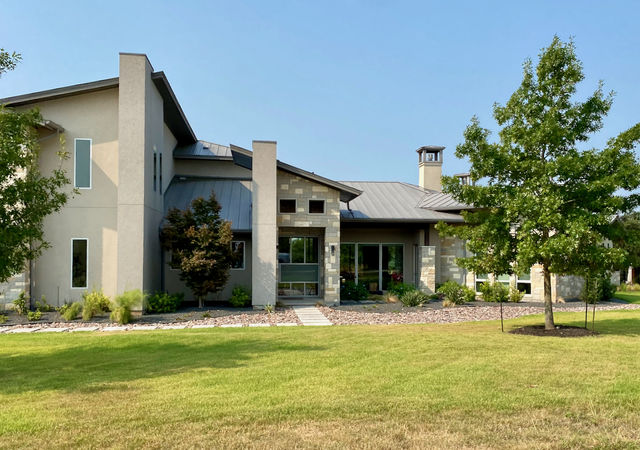 Modern home with grey stucco and stone exterior.