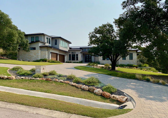 two story limestone and stucco home with metal roof.  Circle drive brick.