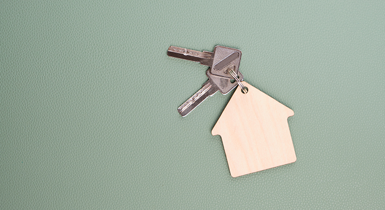 Keys to a home with a house keychain on it