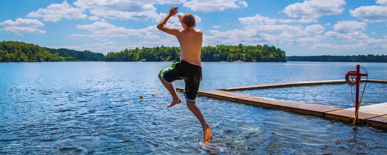 boy jumping into the lake