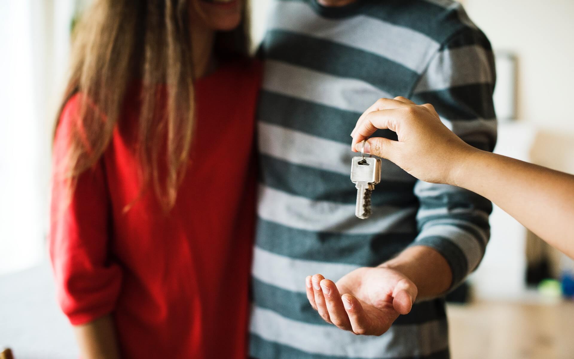 Real Estate agent giving couple a house key