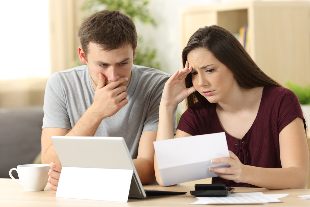 A worried couple read a foreclosure notice
