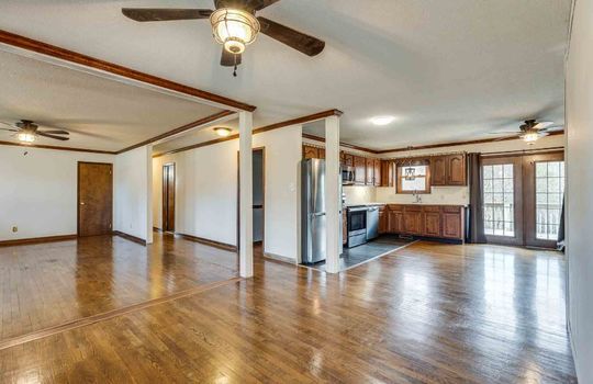 living room, kitchen, dining room. hardwood flooring, ceiling fans, hallway