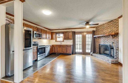 Kitchen and dining area, brick fireplace, cabinets, french doors, refrigerator, stove, microwave, dishwasher
