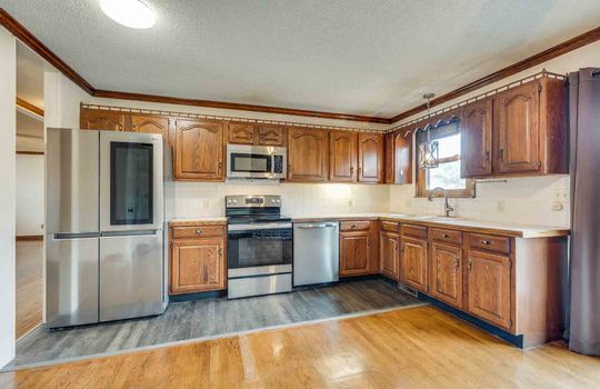 Kitchen, hardwood flooring, cabinets, counters, sink, refrigerator, built in microwave, oven/stove, dishwasher