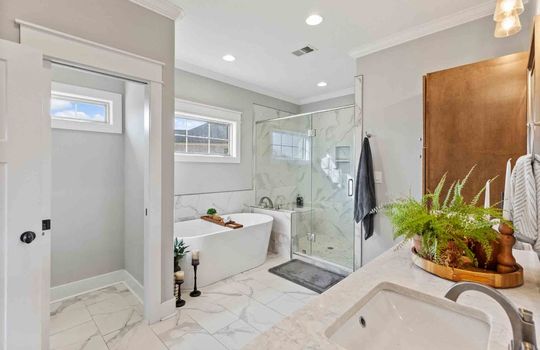 water closet, soaker tub, glass enclosed shower, double vanity, tile flooring, windows