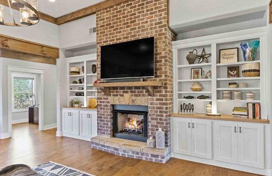 Fireplace, built-in shelving, mantle, hardwood flooring, wood beams