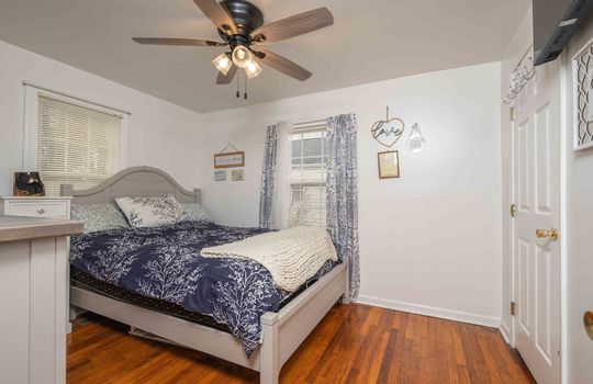 bedroom, hardwood flooring, ceiling fan, windows, doors.