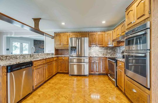 kitchen, dishwasher, refrigerator, wall oven, range/stove, granite counters, tile backsplash, parquet flooring, cabinets