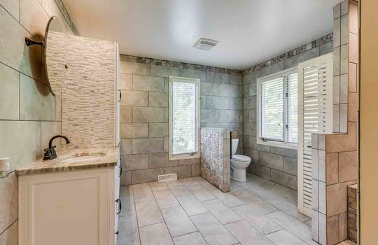 primary bath, toilet, sink, tile flooring, tile walls